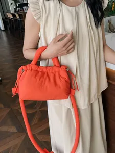 Vibrant orange quilted puffer cloud bag with drawstring and versatile crossbody strap