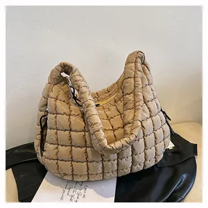 Close-up of khaki quilted puffer shoulder bag with square stitching and zip closure