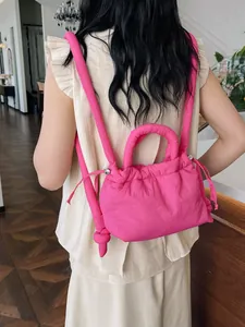 Vibrant pink puffer backpack with quilted texture and padded straps shown on a model