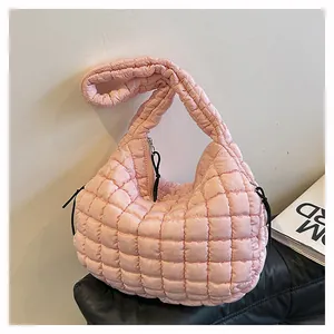 Detail of light pink quilted cloud bag showing soft padded texture and drawstring accents