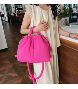Detailed view of magenta puffer handbag with drawstring closure and quilted texture