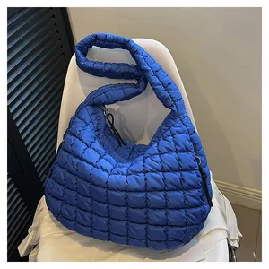 Detail of royal blue quilted puff shoulder bag with soft padded texture and zipper