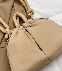 Detailed close-up of khaki quilted puffer tote bag with stylish knotted handle design