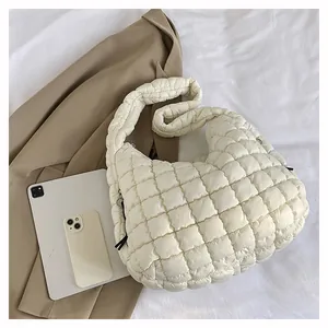 Detailed top view of large white quilted puffer tote bag with office essentials