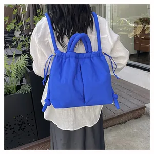 Close-up of klein blue quilted nylon backpack showing fluffy texture and drawstring detail