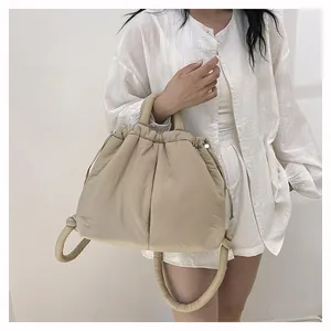 Detailed view of the beige quilted puffy shoulder bag with soft textured handle
