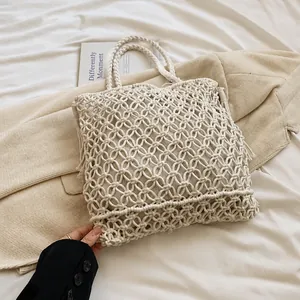 Close-up of beige Bohemian woven handbag featuring intricate geometric circular patterns