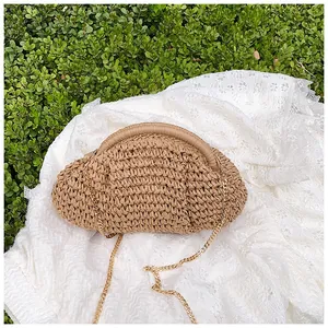 Détail du sac nuage en paille avec chaîne dorée sur dentelle blanche et fond vert