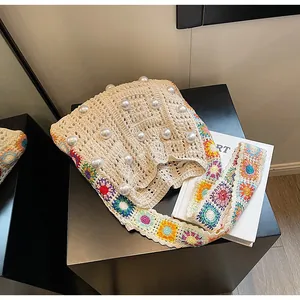 Detail der Häkeltasche mit Perlenakzenten und floralem Strick-Schultergurt