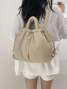 Padded beige nylon backpack with quilted design and drawstring closure for women