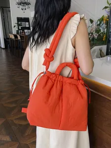 Bright orange puffy nylon shoulder bag with drawstring closure and knotted thick strap
