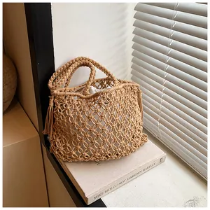 Detail of bohemian hollow knit tote with macrame texture and fringe tassel charm