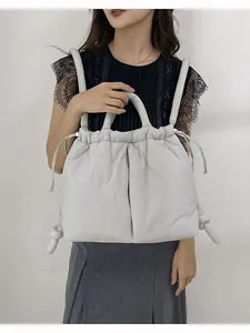 Quilted light gray nylon puffer backpack for women featuring a stylish padded texture