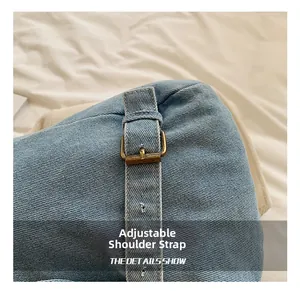 Detalle de la correa ajustable de mezclilla con hebilla de bronce en la mochila