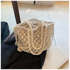 Detail of bohemian beige woven tote bag with fringe accents and drawstring lining