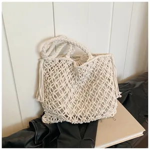 Close-up of handmade macrame knit tote bag featuring long fringes and detailed woven texture