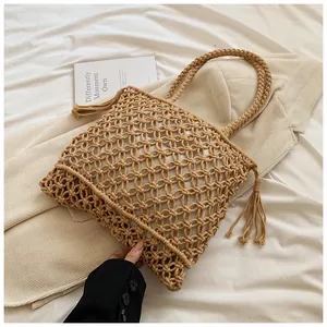Detail of bohemian hand-woven mesh bag featuring stylish tassels and round top handles