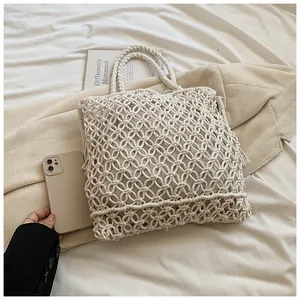 Macro detail of beige macrame knit pattern and thick woven handle on large tote bag