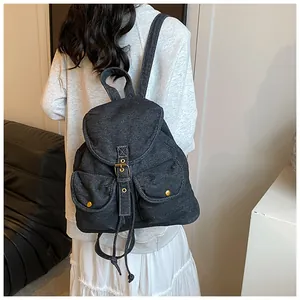Primer plano de mochila retro en denim negro con hebillas metálicas y detalles de textura
