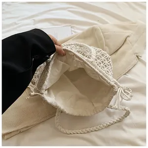 Detail of bohemian cream woven tote bag with hollow pattern and canvas drawstring liner