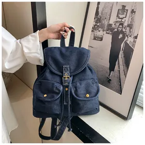 Vista detallada de la mochila de mezclilla azul vintage con hebillas y bolsillos frontales