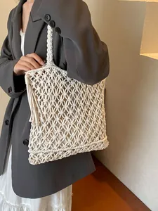 Bohemian white woven beach tote with fringe detail and long handles for summer vacations