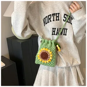 Close-up of handmade green knitted bucket bag with 3D sunflower crochet detail