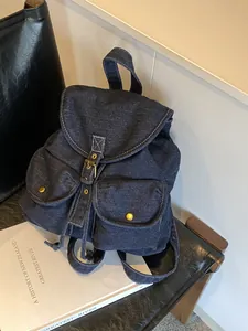Mochila vintage de mezclilla azul oscuro con costuras blancas y hebillas doradas