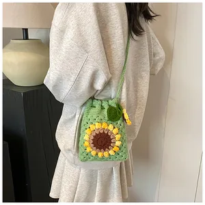 Detail of hand-crocheted green bucket bag with sunflower pattern and drawstring closure