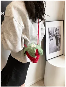 Detailed close-up of handmade crochet strawberry bag with vibrant red and green yarn patterns