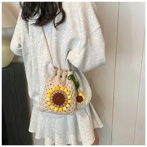 Detail of hand-knitted drawstring bucket bag with 3D sunflower floral pattern