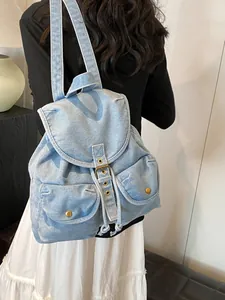 Mochila vintage de mezclilla azul claro con hebillas mostrada en vista trasera de modelo