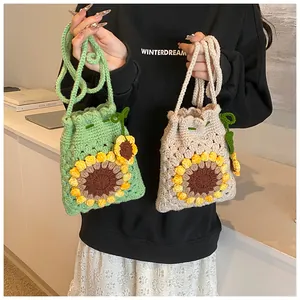 Detail of hand-crocheted drawstring bucket bags with 3D sunflower pattern and knit straps