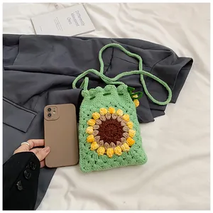Close-up of handmade green crochet bucket bag featuring a bright sunflower motif pattern