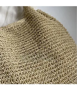 Close-up of the intricate cross-woven straw texture and natural raffia craft on a tote bag