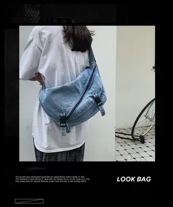 Dettaglio della borsa a tracolla in denim azzurro con fibbie di sicurezza e cerniera