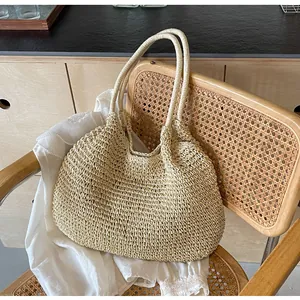 Close-up detail of the intricate hollow-out weaving texture of this beige straw tote bag