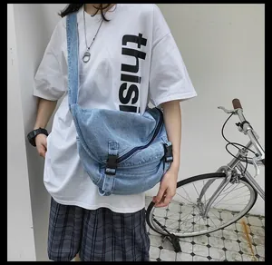 Dettaglio della borsa a tracolla in denim azzurro con fibbia e cerniera lampo