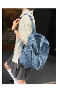 Detail of vintage denim backpack with washed finish showing multi-pocket street style design