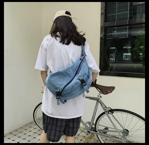 Pratica borsa a tracolla in denim blu con fibbie regolabili mostrata all'aperto