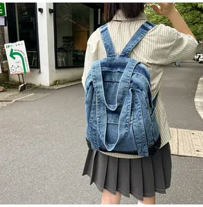 Outdoor street shot of a vintage blue denim backpack with dark contrast bottom stitching