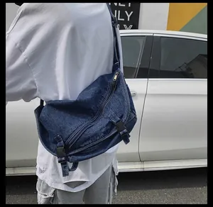 Dettaglio della borsa a tracolla in denim blu scuro con trama lavata e tracolla regolabile