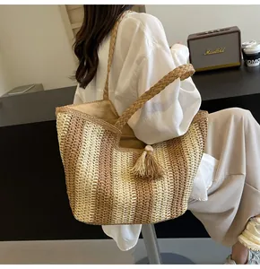 Vista dettagliata della borsa in paglia con nappe eleganti e strisce marroni verticali