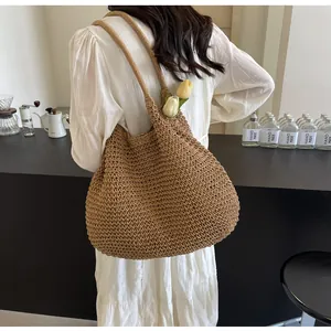 Detail of hand-woven straw tote bag with shoulder strap in a cozy cafe setting