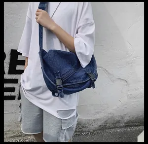 Dettaglio della borsa a tracolla in denim blu scuro con fibbie e catena in metallo