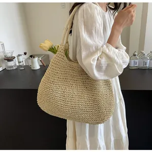 Detailed close-up of large straw tote bag featuring handmade crochet texture and spacious interior