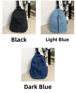 Gewassen denim rugzakken in zwart, lichtblauw en donkerblauw getoond op een bureau