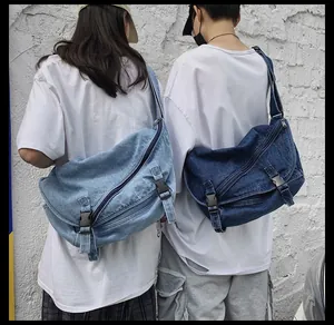 Foto all'aperto di due grandi borse messenger in denim con lavaggio blu chiaro e scuro