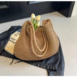 Detail of woven straw tote bag with long shoulder straps and soft textile lining