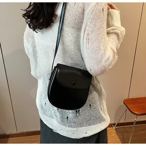 Detailansicht einer schwarzen Vintage-Satteltasche als Umhängetasche an einem Model